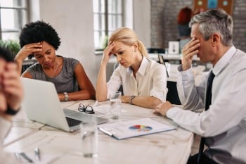 Colleagues looking stressed around a desk