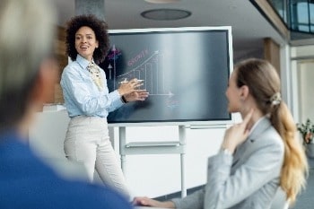 Woman giving presentation to colleagues