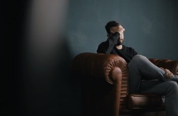 Man sat on sofa looking tired