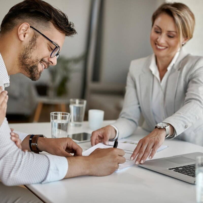 Man signing insurance policy in office